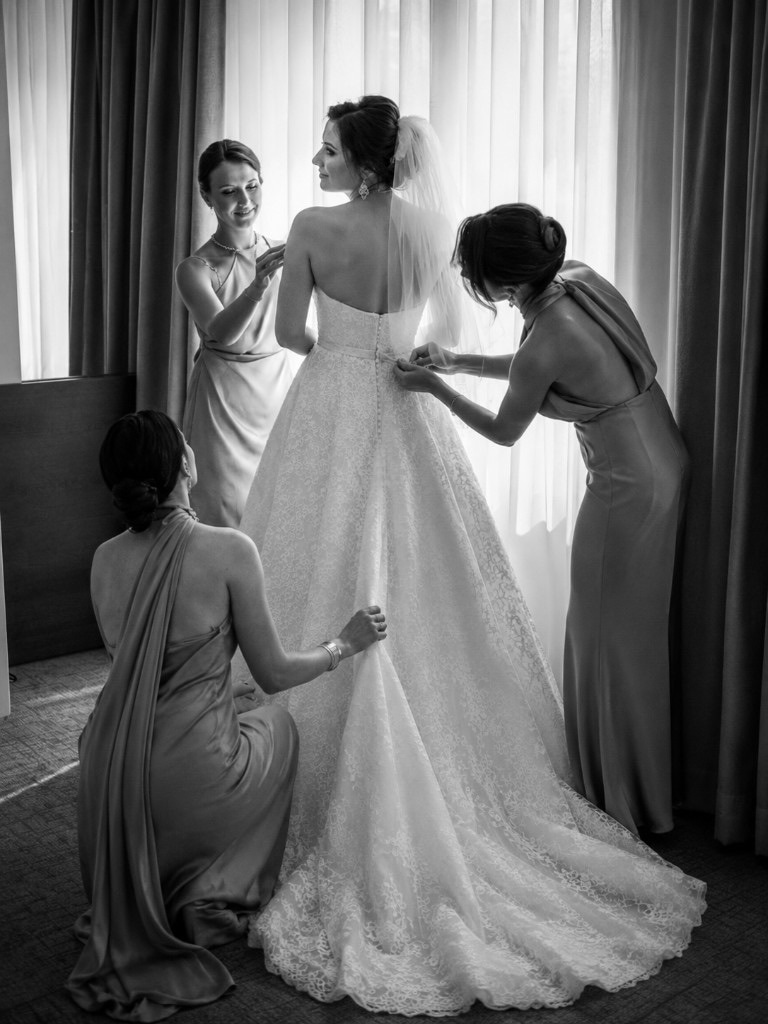 Bridesmaids helping Julia into her dress