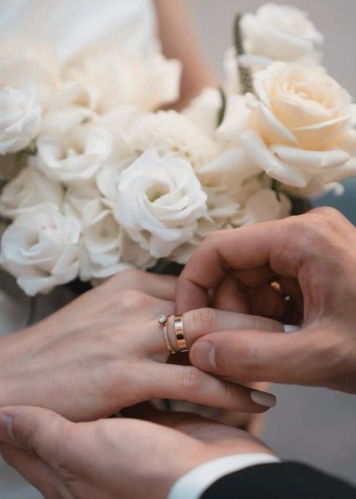 Alex placing the wedding band on Julia’s hand